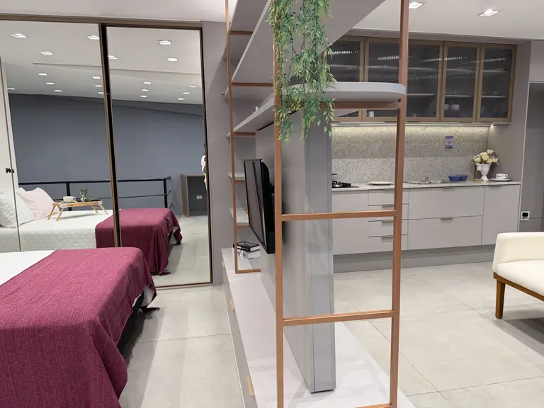 Ambiente completo montado no showroom Raposo Prime, com dormitório, closet e cozinha compacta