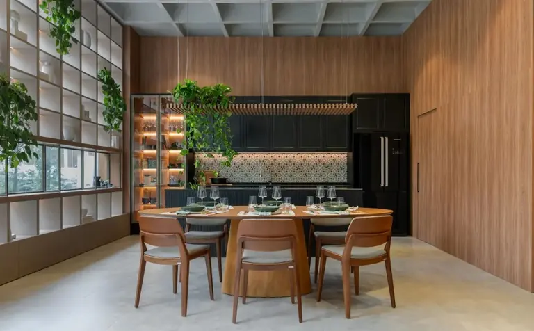 Cozinha planejada com mesa de jantar e revestimento em madeira ripada